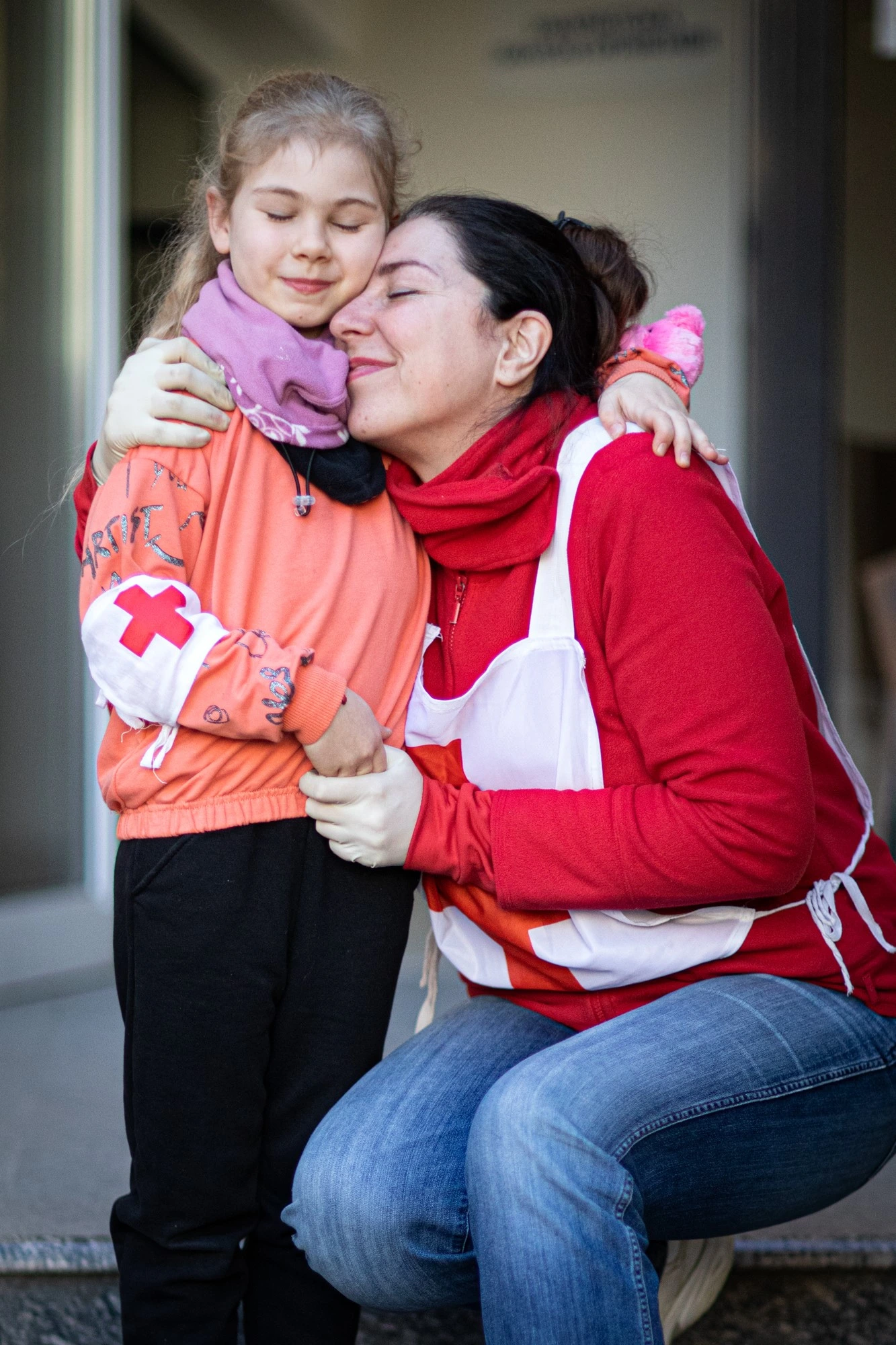 Nine-year old Alyona and her mother receive assistance from Red Cross Volunteers.